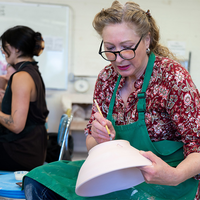 A student working on a pottery piece. A student working on a pottery piece.