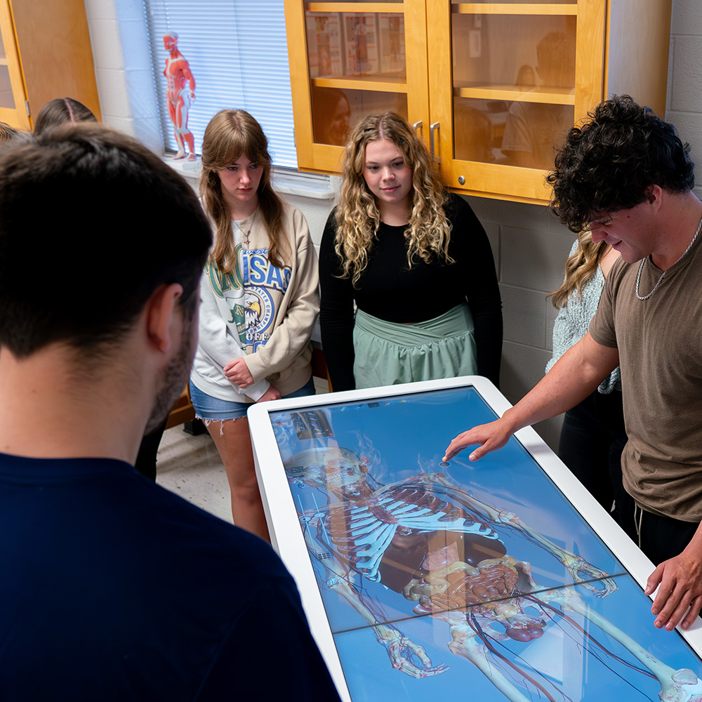 Students using an anatomy table. Students using an anatomy table.